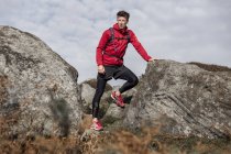 Чоловічий бігун перерви між валуни на Stanage краю, Peak District, Дербішир, Велика Британія — стокове фото