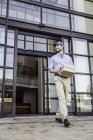 Delivery man carrying package outside office — Stock Photo