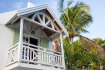 Mature woman standing on balcony of house, Roches Noire, Mauritius — Stock Photo