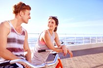 Casal em bicicletas no passeio marítimo — Fotografia de Stock