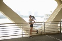 Frau joggt auf erhöhtem Gehweg, Südbund, shanghai, China — Stockfoto