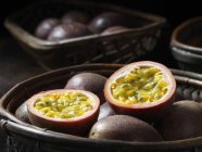 Fresh whole and halved passion fruit in basket — Stock Photo