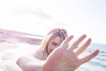 Женщина, прикрывающая лицо на пляже — стоковое фото