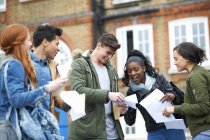 Happy young adult college students reading exam results on campus — Stock Photo