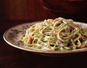 Спагетти со сливочным соусом и лососем на винтажной тарелке — стоковое фото