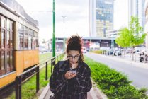 Жінка текстові повідомлення на смартфон в міському районі, Мілан, Італія — стокове фото