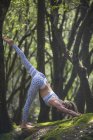 Mulher praticando ioga na floresta — Fotografia de Stock