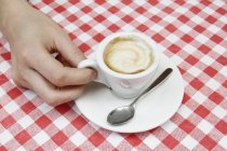 Female hand with espresso at sidewalk cafe table, Milan, Italy — Stock Photo