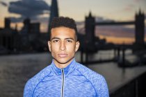 Young man, Tower Bridge in background, Wapping, London, UK — Stock Photo