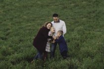 Famiglia insieme in campo che si abbraccia all'aperto — Foto stock