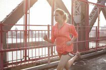 Mujer joven haciendo ejercicio al aire libre, corriendo - foto de stock