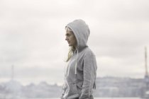 Female runner in grey hoody on misty dockside — Stock Photo