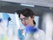 Исследователь пробивает образец ДНК в флакон пендорфа в лаборатории — стоковое фото