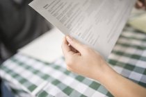Cropped view of woman's hands holding menu — Stock Photo