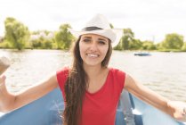 Щаслива молода жінка веслує на човні в парку — стокове фото