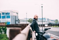 Зрілий чоловічий мотоцикліст дивиться з узбіччя — стокове фото