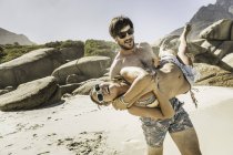 Homme portant une petite amie d'armes sur la plage, Cape Town, Afrique du Sud — Photo de stock