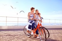 Pareja en bicicleta en el paseo marítimo - foto de stock