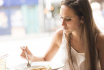 Junge Frau isst Mittagessen in Restaurant — Stockfoto