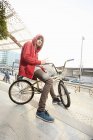 Portrait of young man sitting on BMX in urban area — Stock Photo