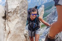 Mujer subiendo la montaña sonriendo, Austria - foto de stock