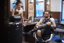 Hairdressers taking a break in barbershop — Stock Photo