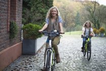 Due sorelle in bicicletta insieme nel parco — Foto stock