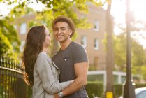 Молода пара на вулиці обіймається і посміхається — стокове фото