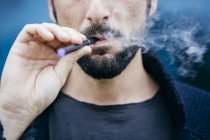 Портрет человека, курящего электронную сигарету — стоковое фото