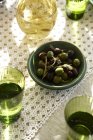 Top view of warmed olives in bowl with white wine and water — Stock Photo