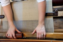 Руки молодой женщины, использующей ткацкий станок — стоковое фото