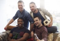 Gruppe männlicher Freunde mit italienischer Flagge, die Fußball und Bierflaschen in die Kamera lächelnd halten — Stockfoto