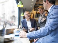 Geschäftsleute diskutieren auf Fensterbank im Restaurant — Stockfoto