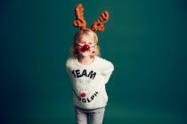 Портрет молодой девушки с рождественскими рогами, оленями и красным носом — стоковое фото