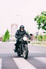 Male motorcyclist motorcycling on pedestrian crossing — Stock Photo