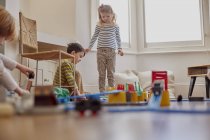 Young girl and boy playing with toy train set — Stock Photo