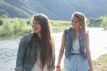Young women standing by river — Stock Photo