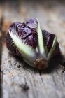 Whole purple lettuce on rough wood surface — Stock Photo