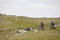 Cyclists cycling on rocky hillside — Stock Photo