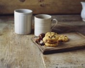 Chocolate and hazelnut cookies on vintage wooden cutting board — Stock Photo