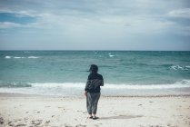 Vue arrière de la femme sur la plage regardant l'océan, Sorso, Sassari, Italie — Photo de stock
