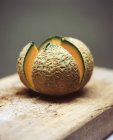 Melone melone melone affettato aperto su tagliere in legno rustico — Foto stock