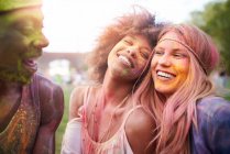 Grupo de amigos en el festival, cubierto de pintura en polvo de colores - foto de stock