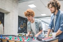 Co-workers playing foosball at break together — Stock Photo