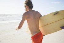 Junger männlicher Surfer läuft am Strand, Kapstadt, Westkap, Südafrika — Stockfoto