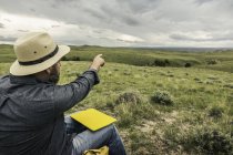 Мужчина-турист указывает на пейзаж, Коди, Вайоминг, США — стоковое фото