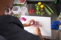 Cropped view of man slicing red onion — Stock Photo