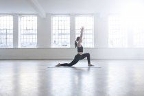 Side view of woman in dance studio in yoga position — Stock Photo