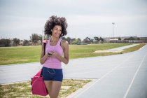 Junge Frau beim Training, hört auf der Laufstrecke Kopfhörer — Stockfoto
