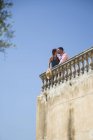 Besos en pareja en el balcón de la azotea en el hotel boutique, Mallorca, España - foto de stock